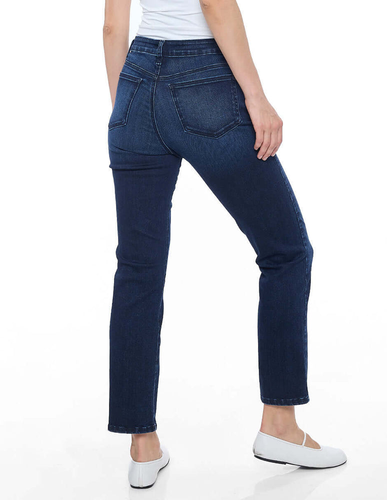 
                  
                    Modelo usando jeans recto color azul marino, vista posterior, estilo casual y cómodo. Temporada Otoño - Invierno 2025.
                  
                